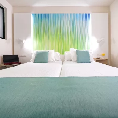 Une vue centrée sur les deux lits simples, mettant en avant le design moderne de la pièce.