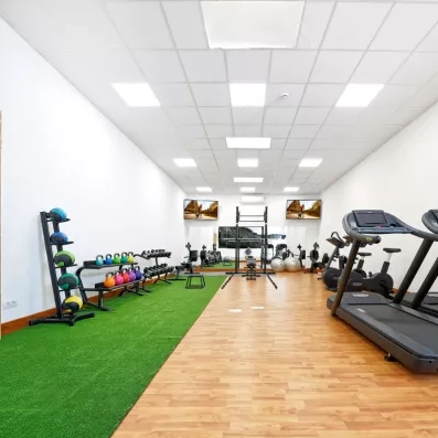 Une salle de sport moderne équipée d'un espace de musculation et d'une zone de cardio.