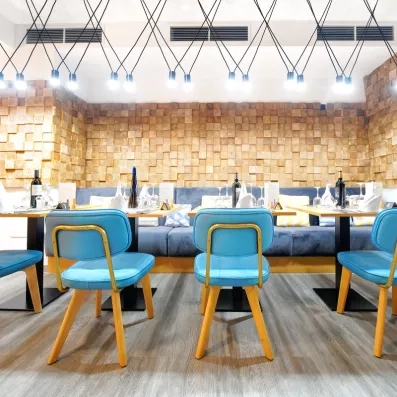 Une salle décorée de murs en briques avec des chaises bleu turquoise modernes.