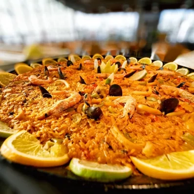 Un gros plan appétissant sur une grande paëlla garnie de crevettes.