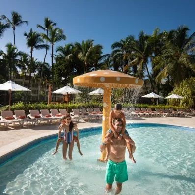 Des enfants s'amusent dans une piscine équipée de jeux d'eau.