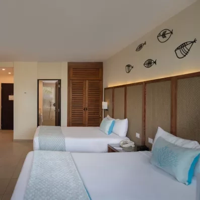 Une chambre spacieuse avec deux lits doubles et une décoration murale.