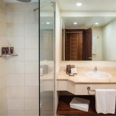 Une salle de bain lumineuse propose une douche à l'italienne avec paroi vitrée.