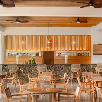 Un bar chaleureux en bois avec des tabourets hauts et une décoration murale.