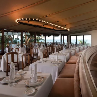 Une salle de réception, offrant une vue panoramique sur la mer à travers de grandes baies vitrées.