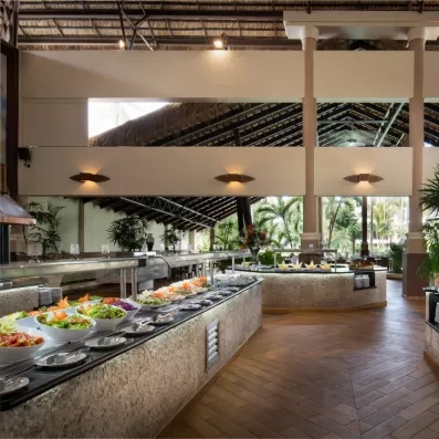 Un buffet spacieux et bien éclairé présentant un large choix de plats frais sous une haute structure de toit apparente.