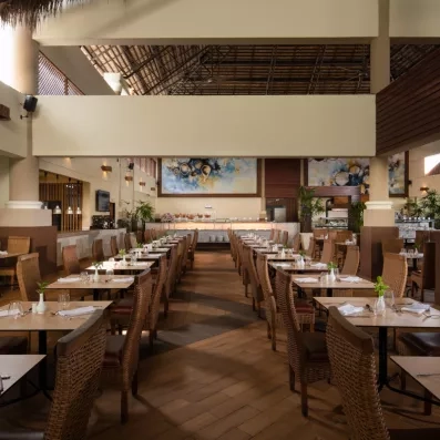 Une salle de restaurant élégante avec de longues rangées de tables en bois.