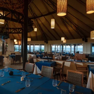 Un restaurant à l'ambiance tamisée, offrant une vue panoramique sur l'extérieur.