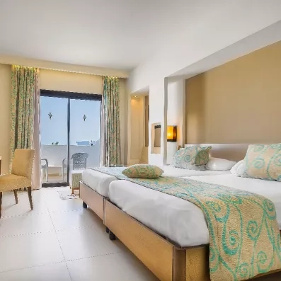 Chambre double spacieuse avec balcon et décoration turquoise moderne pour un séjour détente au Palm Azur.