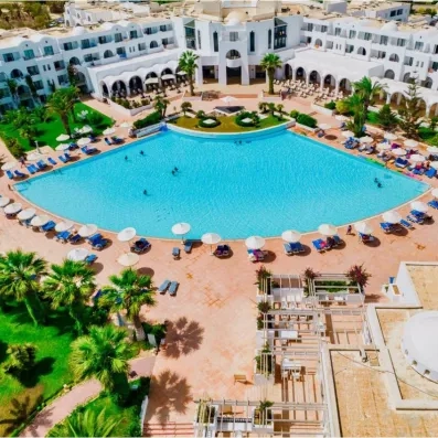 Vue aérienne de la grande piscine turquoise et de l'architecture blanche typique du Palm Azur à Djerba.