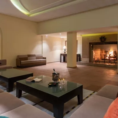 Salon de détente chaleureux avec cheminée et apéritif servi pour une soirée conviviale au Marhaba Salem.