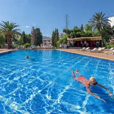Grande piscine extérieure ensoleillée avec nageurs et scène d'animation pour des vacances actives au Marhaba Salem.
