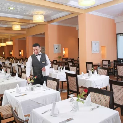 Serveur professionnel mettant le couvert dans la salle de restauration raffinée du complexe hôtelier Marhaba Salem.