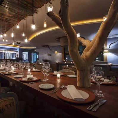 une table au restaurant bien dressée avec une branche d'arbre et du luminaire