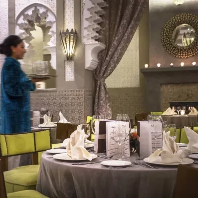 restaurant décoré en vert et gris avec tables et chaises et couverts