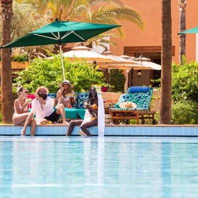 piscine de l'hôtel avec des clients sous les parasols 