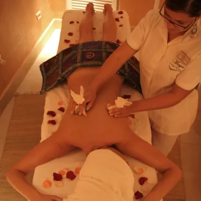 Séance de massage relaxant avec pétales de fleurs au centre de thalassothérapie du Djerba Aqua Resort.