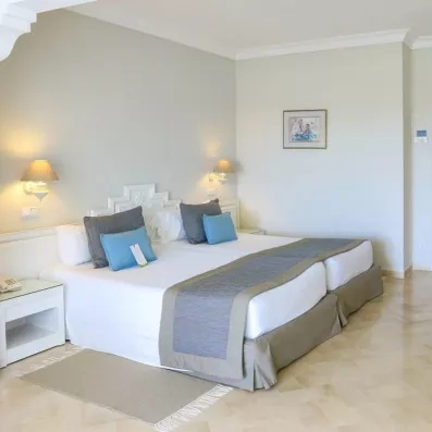 Chambre spacieuse et lumineuse avec décoration élégante et tons bleus apaisants au Royal Garden Palace à Djerba.