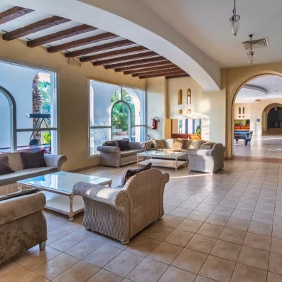 Grande piscine bleue scintillante du Djerba Resort bordée de palmiers sous un ciel d'été radieux.