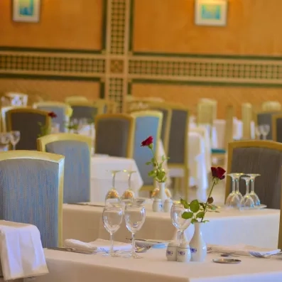 Dressage de table raffiné avec roses rouges pour un dîner romantique au Royal Garden Palace Djerba.