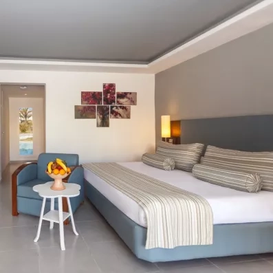 Suite élégante au César Thalasso Djerba avec coin salon, corbeille de fruits et décoration moderne épurée.
