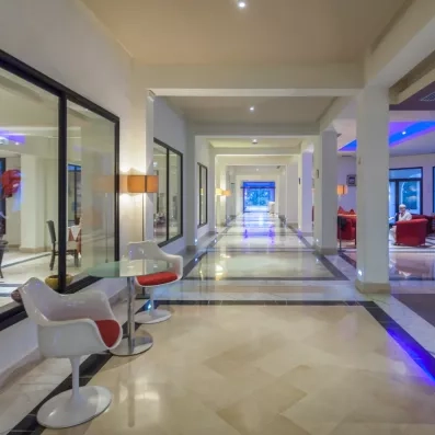 Couloir moderne et lumineux de l'hôtel César Thalasso Djerba menant aux espaces de vie et détente.