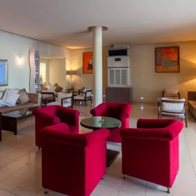 Espace lounge moderne avec fauteuils rouges confortables pour se détendre à l'hôtel César Thalasso.