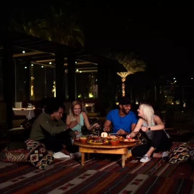 Dîner convivial entre amis en terrasse au Mövenpick Soma Bay, expérience culturelle et culinaire à Hurghada.