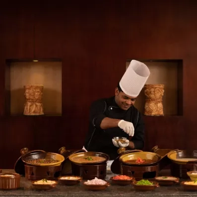Chef préparant des spécialités locales au buffet du Mövenpick Waterpark Resort, gastronomie de voyage en Égypte.