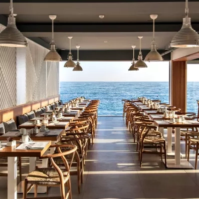 Restaurant  de l'hôtel avec des tables et des couverts avec une vue sur mer