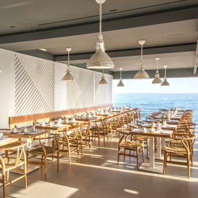 Restaurant  de l'hôtel avec des tables et des couverts avec une vue sur mer
