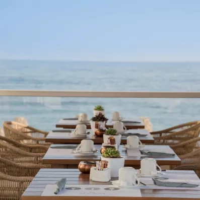 Restaurant  de l'hôtel avec des tables et des couverts avec une vue sur mer