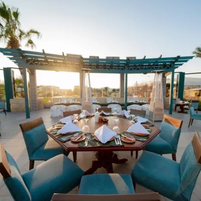 Table extérieure sous pergola au coucher du soleil, restaurant romantique du Mövenpick Soma Bay en Égypte.