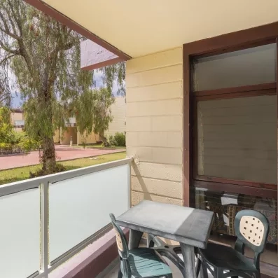 Un balcon privatif avec une petite table et des chaises, idéal pour profiter de la vue sur le parc.