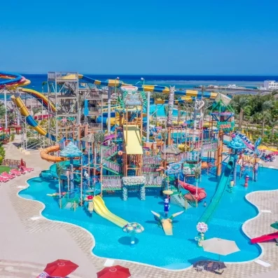 Vue panoramique sur la grande piscine et toboggans du parc aquatique, plage, palmiers