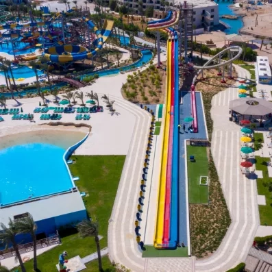 Vue de haut des piscines extérieurs avec les toboggans du parc aquatique , transats, parasols, soleil