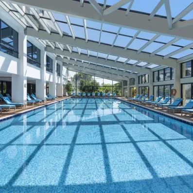 grande piscine intérieure avec des transats