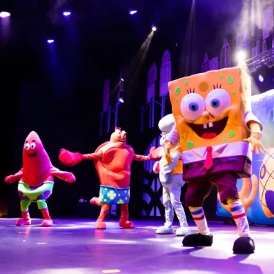spectacle avec des mascottes sur scène vue de nuit