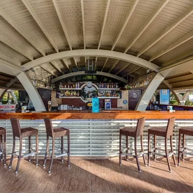 Bar de piscine avec comptoir et chaises hautes en bois