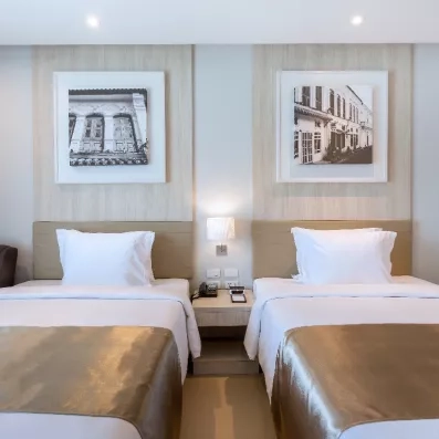 Un plan rapproché sur les lits jumeaux, surmontés de cadres décoratifs en noir et blanc.