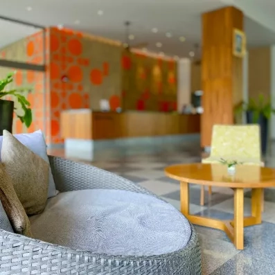 Un coin salon confortable avec un fauteuil, offrant une vue sur le comptoir de réception.