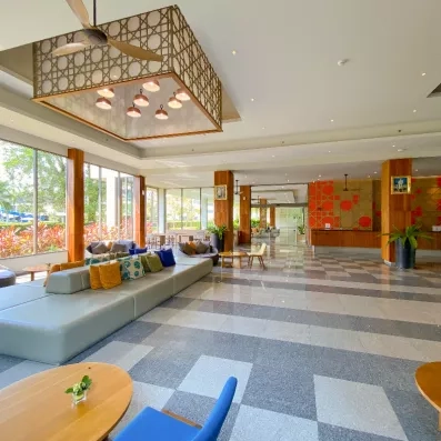 Un hall d'entrée vaste et lumineux, avec des banquettes colorées.