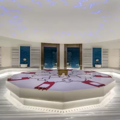 Un hammam traditionnel avec une grande plateforme centrale en marbre.