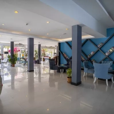 Un hall d'accueil spacieux, avec un mur orné de bibliothèques et des fauteuils.