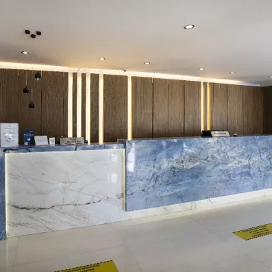 Un comptoir de réception élégant en marbre bleu et blanc, avec un mur en bois.