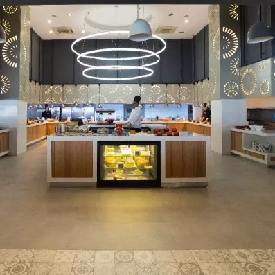 Un grand buffet moderne et lumineux, présentant une sélection de fromages en vitrine.