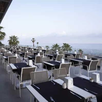 Une vaste terrasse de restaurant en bord de mer offrant une vue panoramique sur l'horizon.