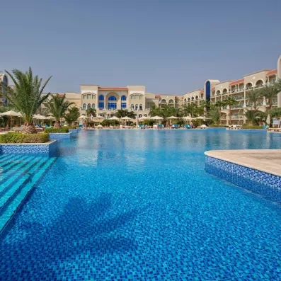 Grande piscine bleu turquoise et façade luxueuse de l'hôtel 5 étoiles Premier Le Rêve à Hurghada.