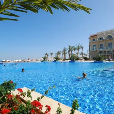 Piscine à débordement avec vue sur la mer et palmiers au Premier Le Rêve Hôtel, Égypte.