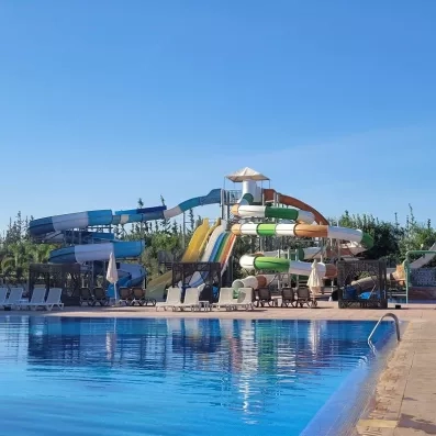 vue sur la piscine en premier plan et au fond des toboggans colorés 